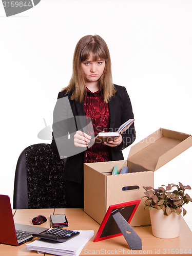 Image of Dismissed girl puts personal belongings in office