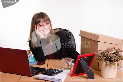 Image of Smiling office employee sitting at the table