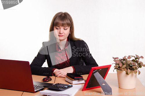 Image of Sad girl sits at office table