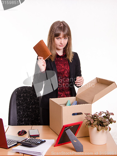 Image of Dismissed girl office throws a notebook in box