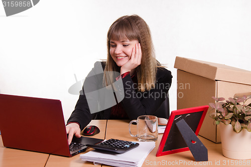 Image of Office employee sitting at computer with a smile