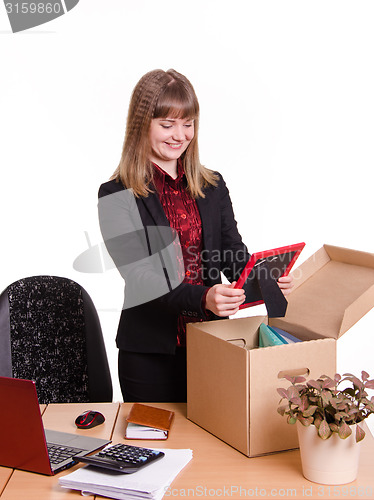Image of Girl puts a photo frame on desktop from box office