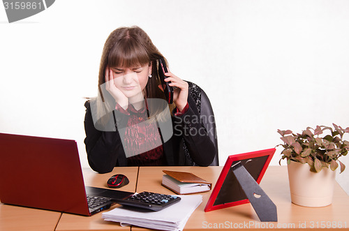 Image of girl behind office desk listening to cry of the phone