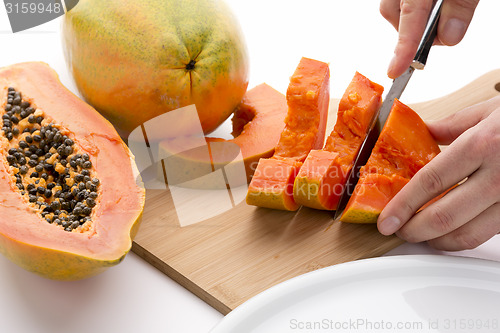 Image of Half A Papaya Fruit Being Cut Into Slices