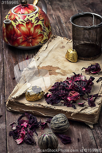 Image of tea accessories amid frayed books