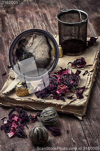 Image of tea accessories amid frayed books