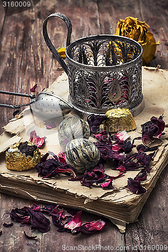 Image of tea accessories amid frayed books