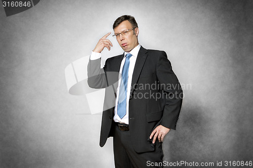 Image of conceited business man pointing finger to head