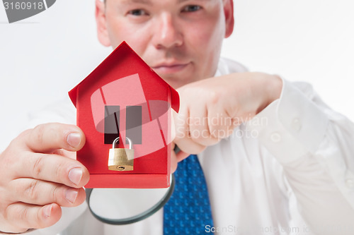 Image of Man with a magnifying glass and paper house