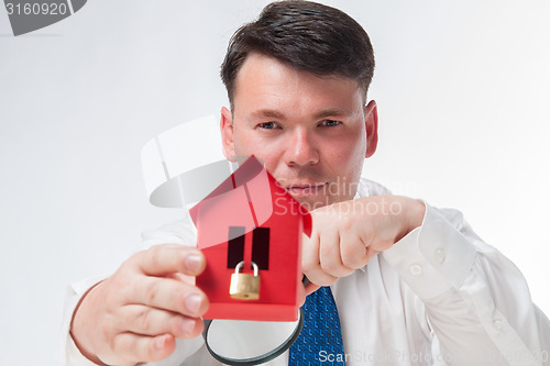 Image of Man with a magnifying glass and paper house