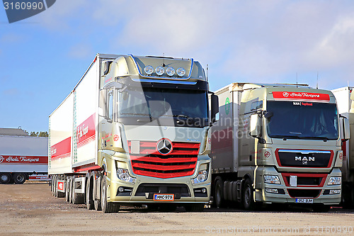 Image of Red Mercedes-Benz Actros and MAN 2551 Trucks on a Yard