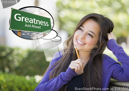 Image of Young Woman with Thought Bubble of Greatness Green Road Sign 