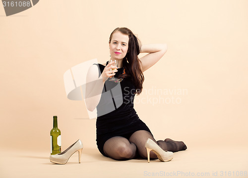 Image of beautiful young brunette woman holding a glass of white wine