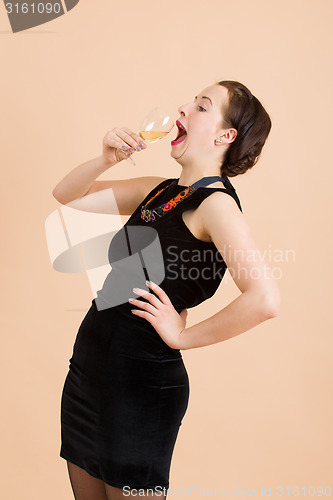 Image of beautiful young brunette woman holding a glass of white wine