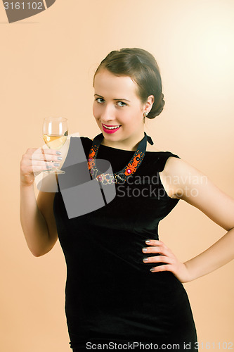 Image of beautiful young brunette woman holding a glass of white wine