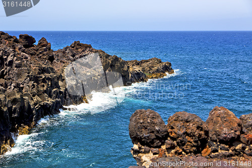Image of brown rock in white coast lanzarote   spain   beach  stone water