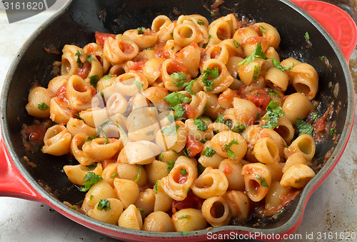 Image of Elbow pasta arrabbiata mixed in a pan