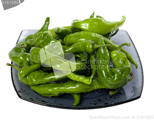 Image of Wet green peppers on glass plate