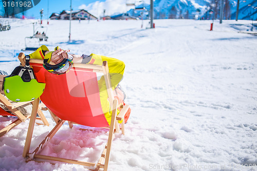 Image of Women at mountains in winter lies on sun-lounger