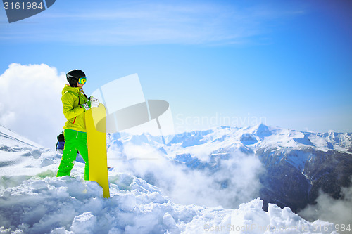 Image of snowboarder against sun and mountains