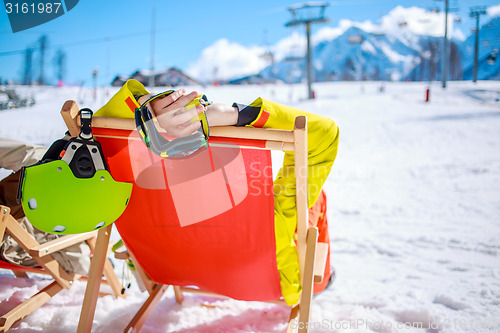 Image of Women at mountains in winter lies on sun-lounger