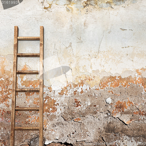 Image of weathered stucco wall with wooden ladder