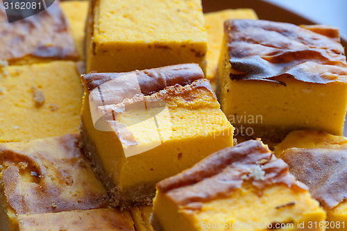 Image of homemade yellow orange cheesecake in pieces