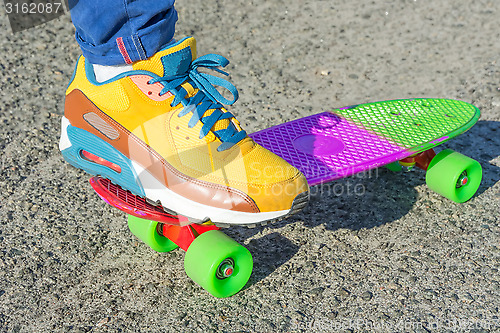 Image of Leg skateboarder on a colorful skateboard.