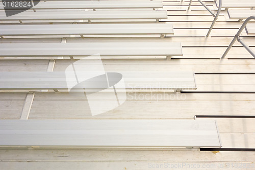 Image of empty bleacher seating in rows, taken in a modern school sports 