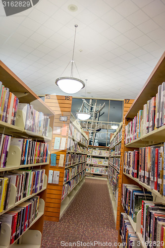 Image of A view of rows of bookshelves and a study area inside a modern l