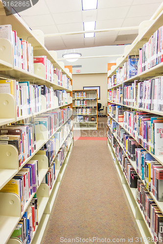 Image of A view of rows of bookshelves and a study area inside a modern l