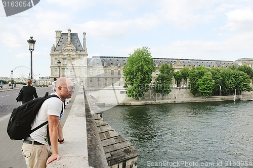 Image of France, Paris - June 17, 2011: People walking in front of famous Louvre museum 