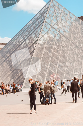 Image of France, Paris - June 17, 2011: Redhead women near pyramid in Louver, Paris