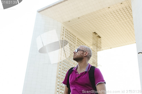 Image of young confident man in business district of Paris