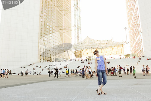 Image of Young confident woman in business district of Paris