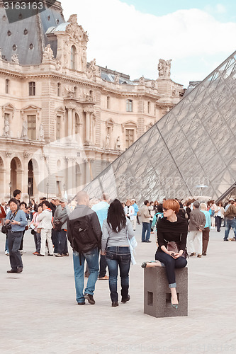 Image of France, Paris - June 17, 2011: Redhead women near pyramid in Louver, Paris