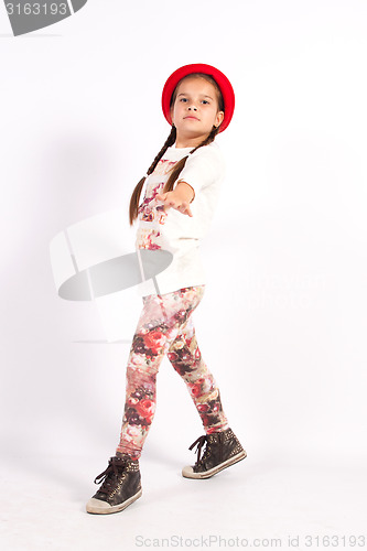 Image of Little girl dance with a red hat with hand in front of you,