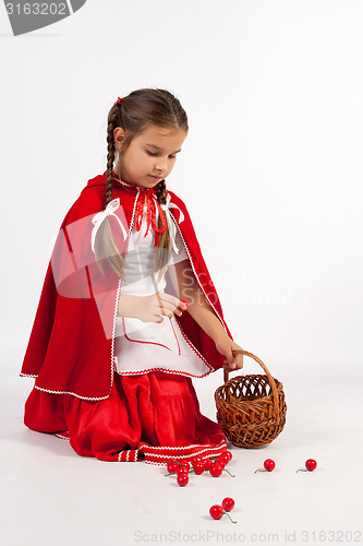 Image of little girl in a costume, collect cherries