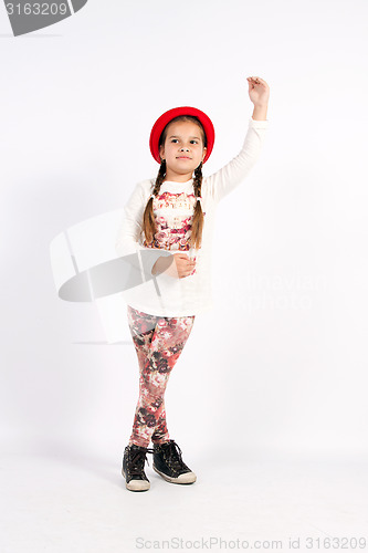 Image of Little girl dance with a red hat with hand in front of you,