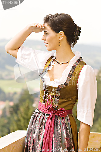 Image of bavarian Girl in a dirndl on a balcony