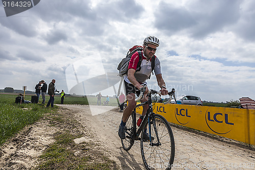 Image of Amateur Cyclist Riding on a Cobblestoned Road