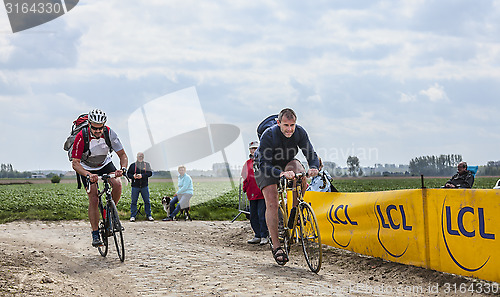 Image of Amateur Cyclists Riding on a Cobblestoned Road