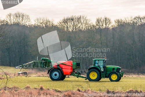 Image of Fertilizing tractor a field