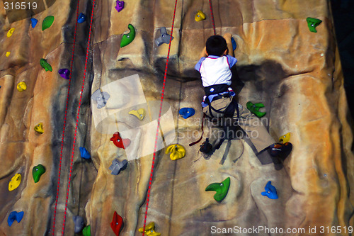 Image of Little boy Climbing A Wall