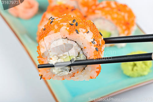 Image of Sushi roll with black chopsticks 