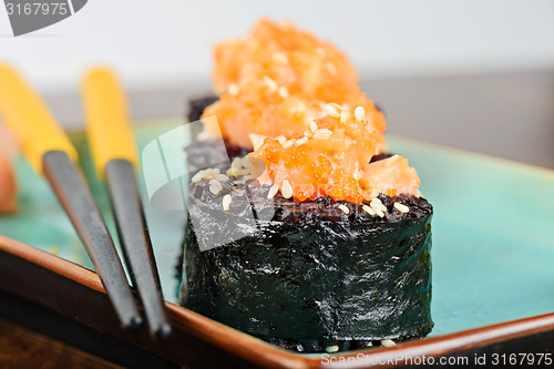 Image of Baked sushi rolls served on turquoise plate