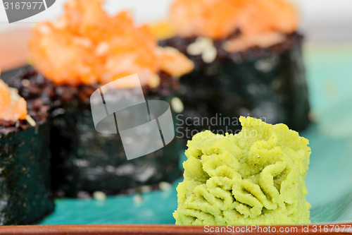 Image of Wasabi with baked sushi rolls on turquoise plate