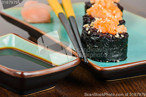 Image of Baked sushi rolls served on turquoise plate