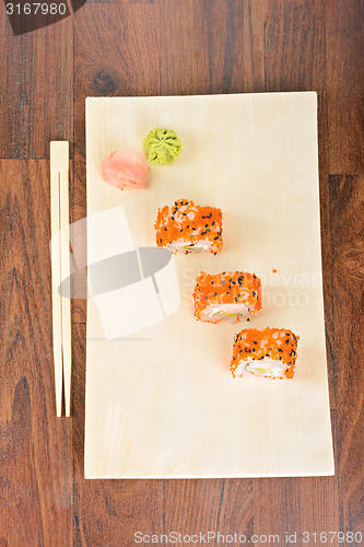 Image of Sushi rolls on the wooden plate. Top view. 