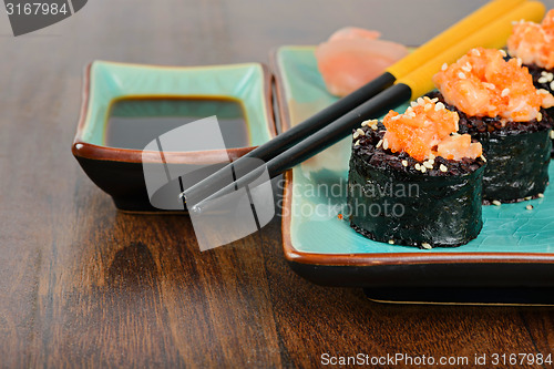 Image of Baked sushi rolls served on blue plate